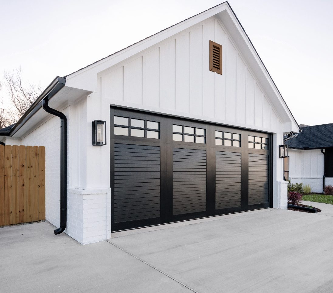 Technician installing a new insulated garage door on a home